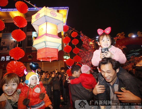 元宵灯会上,孩子兴奋地骑在家长肩上看花灯.