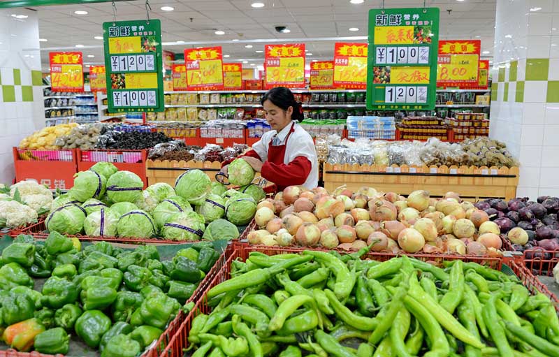 10月14日,工作人员在河北沧州一家超市内摆放蔬菜.牟宇摄影