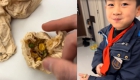 男孩将在学校吃的饭菜 用餐巾纸打包回家给爸爸吃